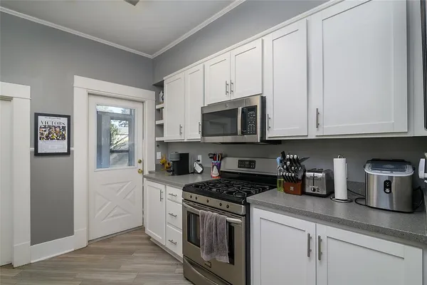 a kitchen with stainless steel appliances granite countertop white cabinets and a stove