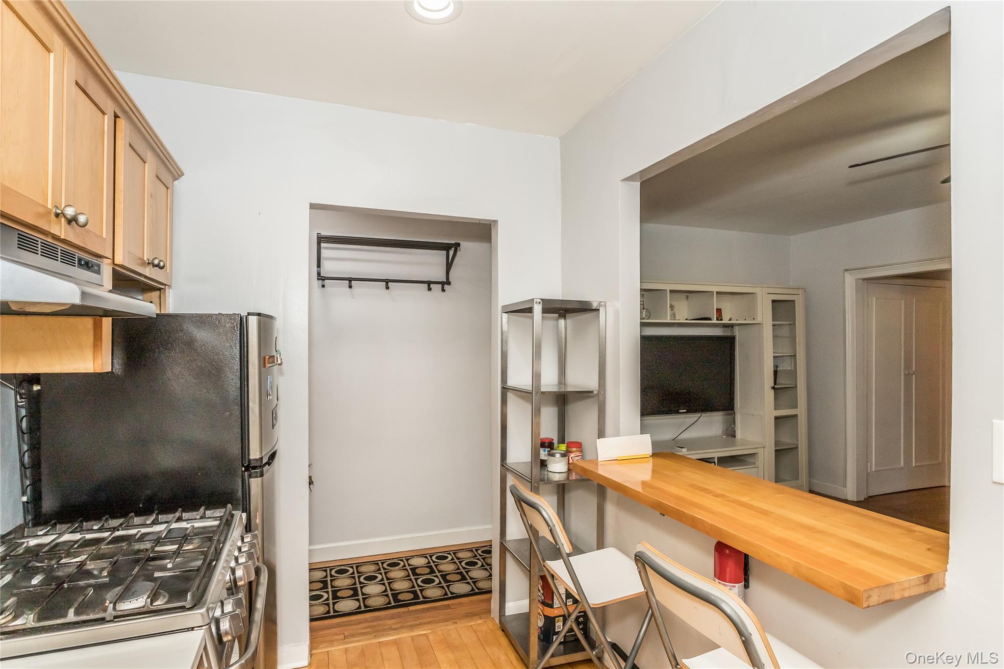 51-28 30th Avenue, Unit 3 Queens, NY 11377 - Photo 8 of 20 Kitchen featuring wood counters, gas range, a breakfast bar, light wood-style flooring, and under cabinet range hood