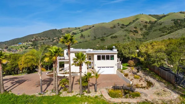 a view of a house with backyard porch and sitting area