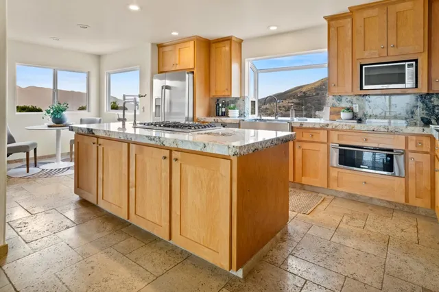 a kitchen with stainless steel appliances granite countertop a stove a sink and a microwave