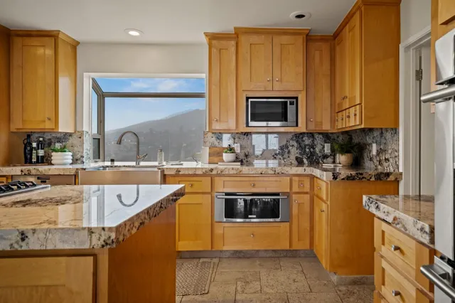 a kitchen with stainless steel appliances granite countertop a sink and a stove
