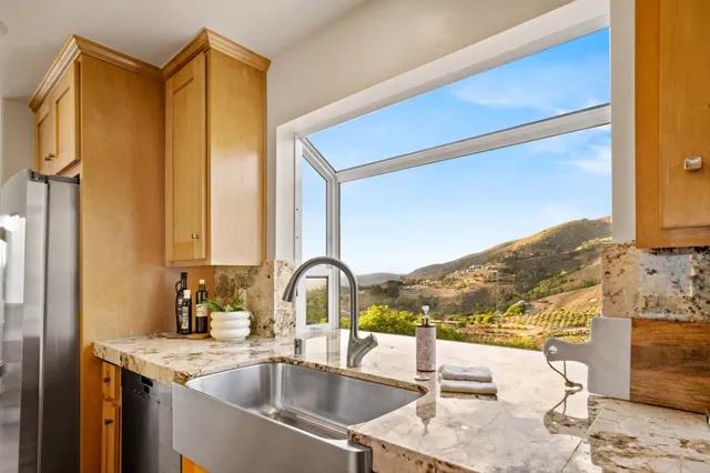 a kitchen with a sink and a view of living room