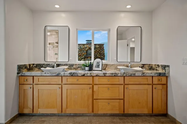 a bathroom with a granite countertop sink and a mirror