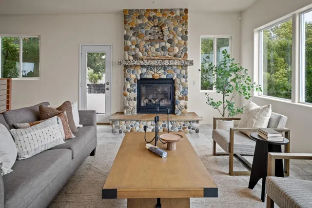 a living room with furniture a large window and a fireplace