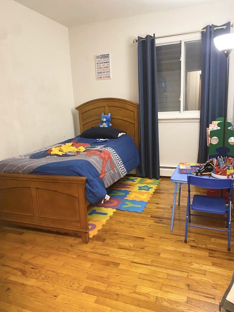34 Trask Avenue, Unit 2 Bayonne, NJ 07002 - Photo 9 of 11 a bedroom with a bed and a table in it