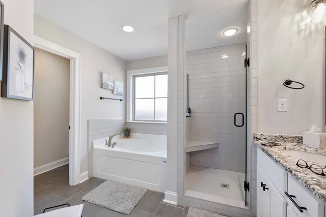 a bathroom with a granite countertop sink a toilet and shower