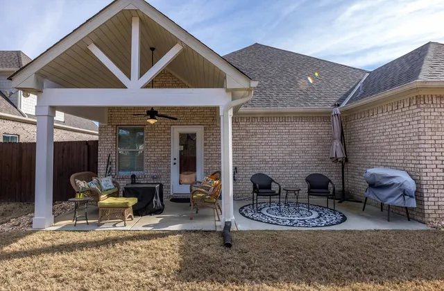 a backyard of a house with fountain table and chairs