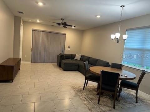 1276 Enbrook Loop Naples, FL 34114 - Photo 4 of 15 a living room with furniture a chandelier and a dining table