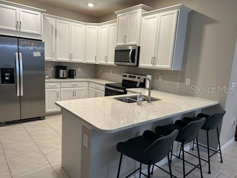 1276 Enbrook Loop Naples, FL 34114 - Photo 5 of 15 a kitchen with stainless steel appliances a microwave sink and cabinets