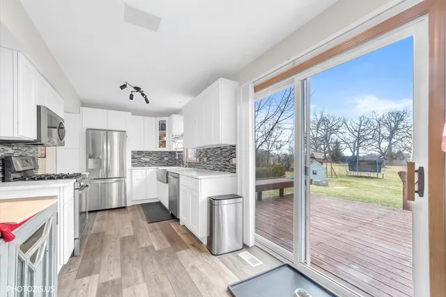 a kitchen with a refrigerator a stove top oven a sink and cabinets