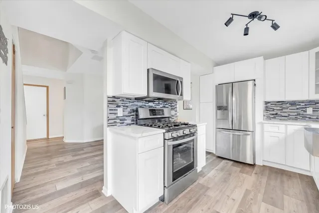 a kitchen with a stove a refrigerator and a microwave