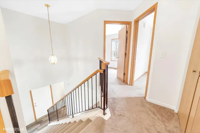 a view of a hallway with wooden floor and stairs