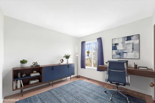 a view of a workspace with furniture and a window