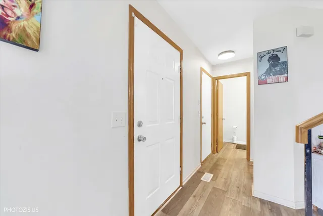 a view of a hallway with wooden floor and closet