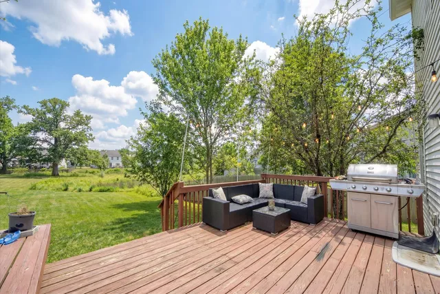 a view of a patio with table and chairs potted plants with wooden floor and fence