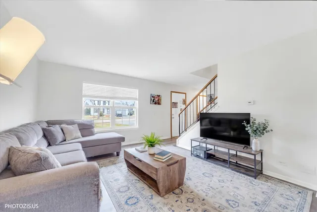 a living room with furniture a flat screen tv and a window