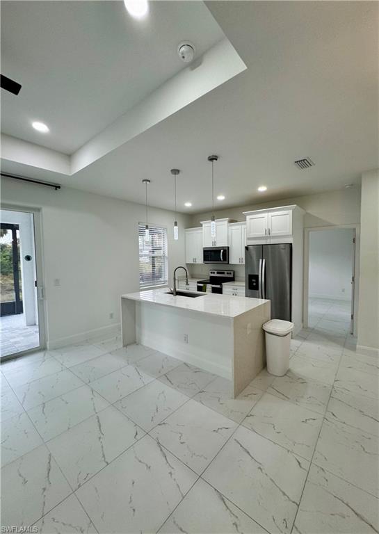 3743 Kenyon Street Fort Myers, FL 33905 - Photo 3 of 18 a large white kitchen with a large window and stainless steel appliances