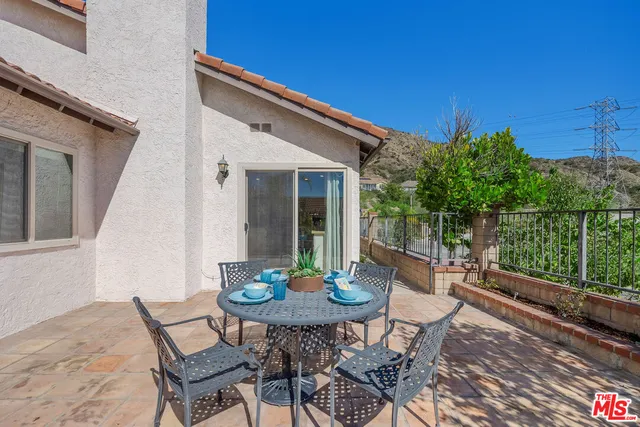 a backyard of a house with table and chairs
