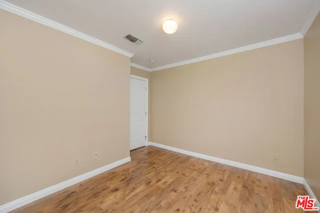 a view of an empty room with window and chandelier fan
