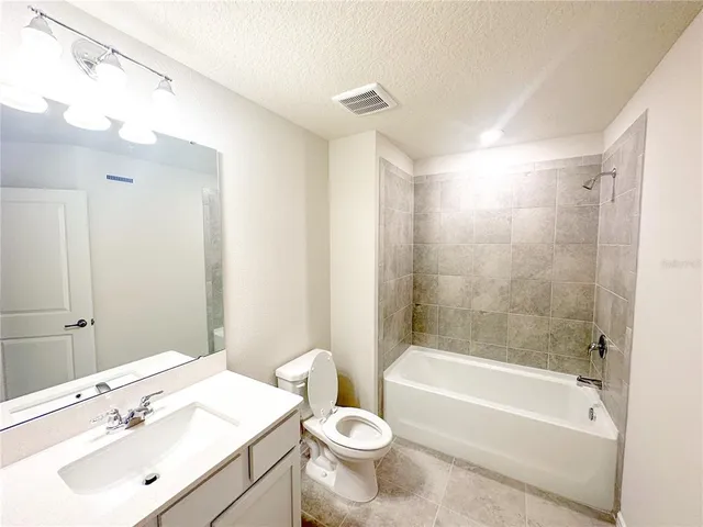 a bathroom with a sink mirror toilet and bathtub