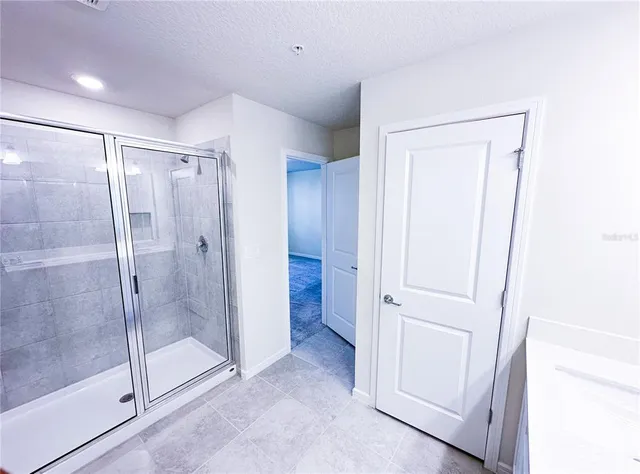 a bathroom with a shower and a glass door