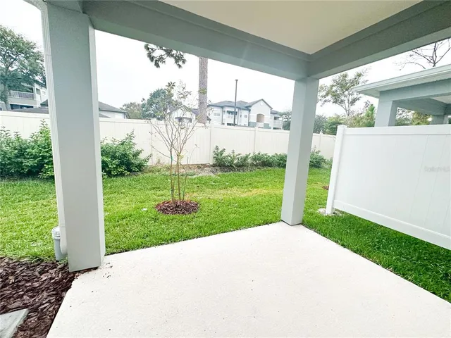 a view of a house with backyard and a patio