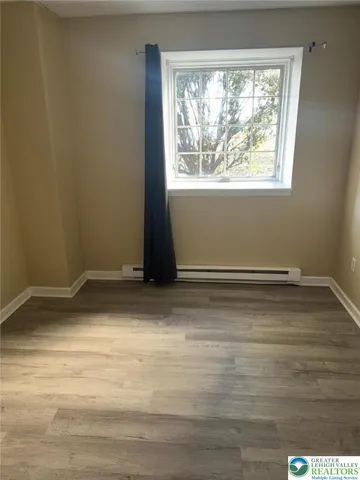 a view of a room with wooden floor and window