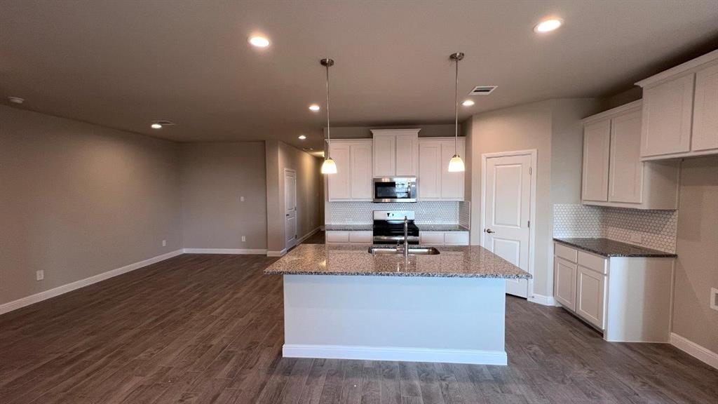 138 Stanton Avenue Rhome, TX 76078 - Photo 1 of 19 a kitchen with kitchen island a counter top space cabinets and stainless steel appliances