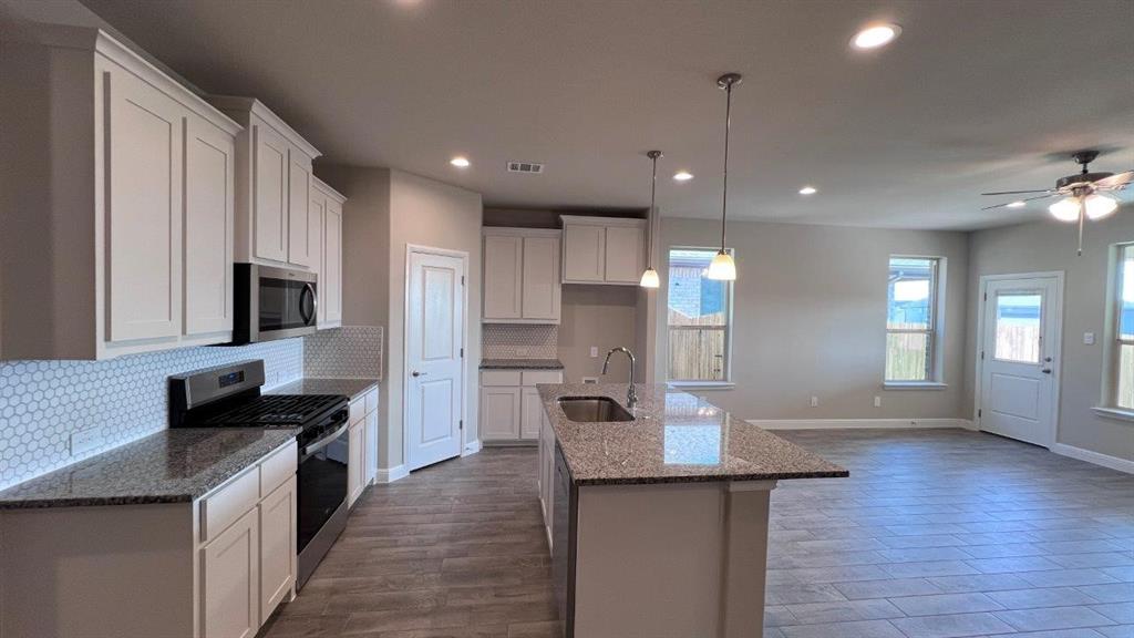 138 Stanton Avenue Rhome, TX 76078 - Photo 2 of 19 a kitchen with stainless steel appliances granite countertop a sink stove and wooden floor