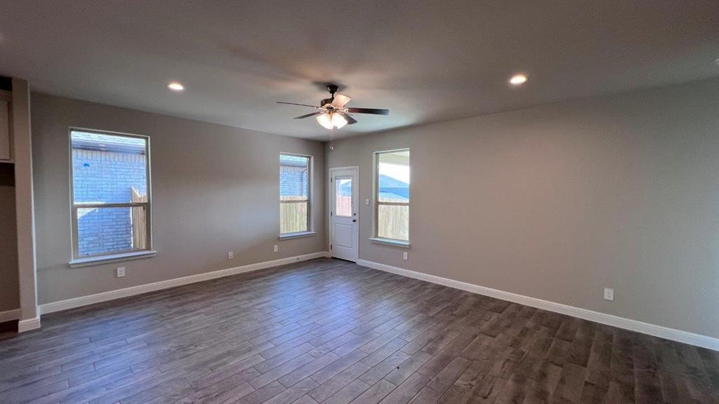 138 Stanton Avenue Rhome, TX 76078 - Photo 6 of 19 a view of an empty room with a window and wooden floor