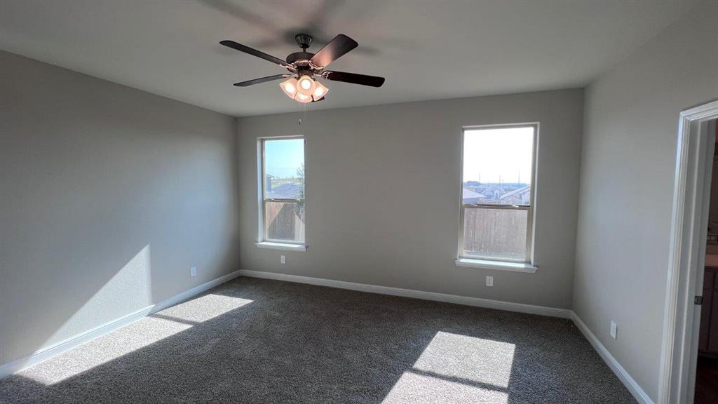 138 Stanton Avenue Rhome, TX 76078 - Photo 7 of 19 an empty room with windows and fan