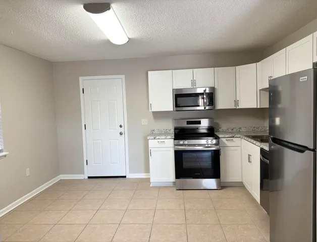 an empty room with fan and entrance