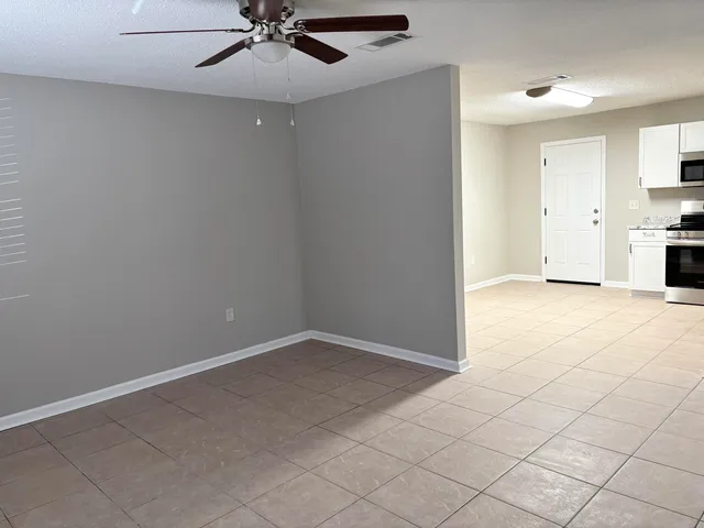 an empty room with windows and fan