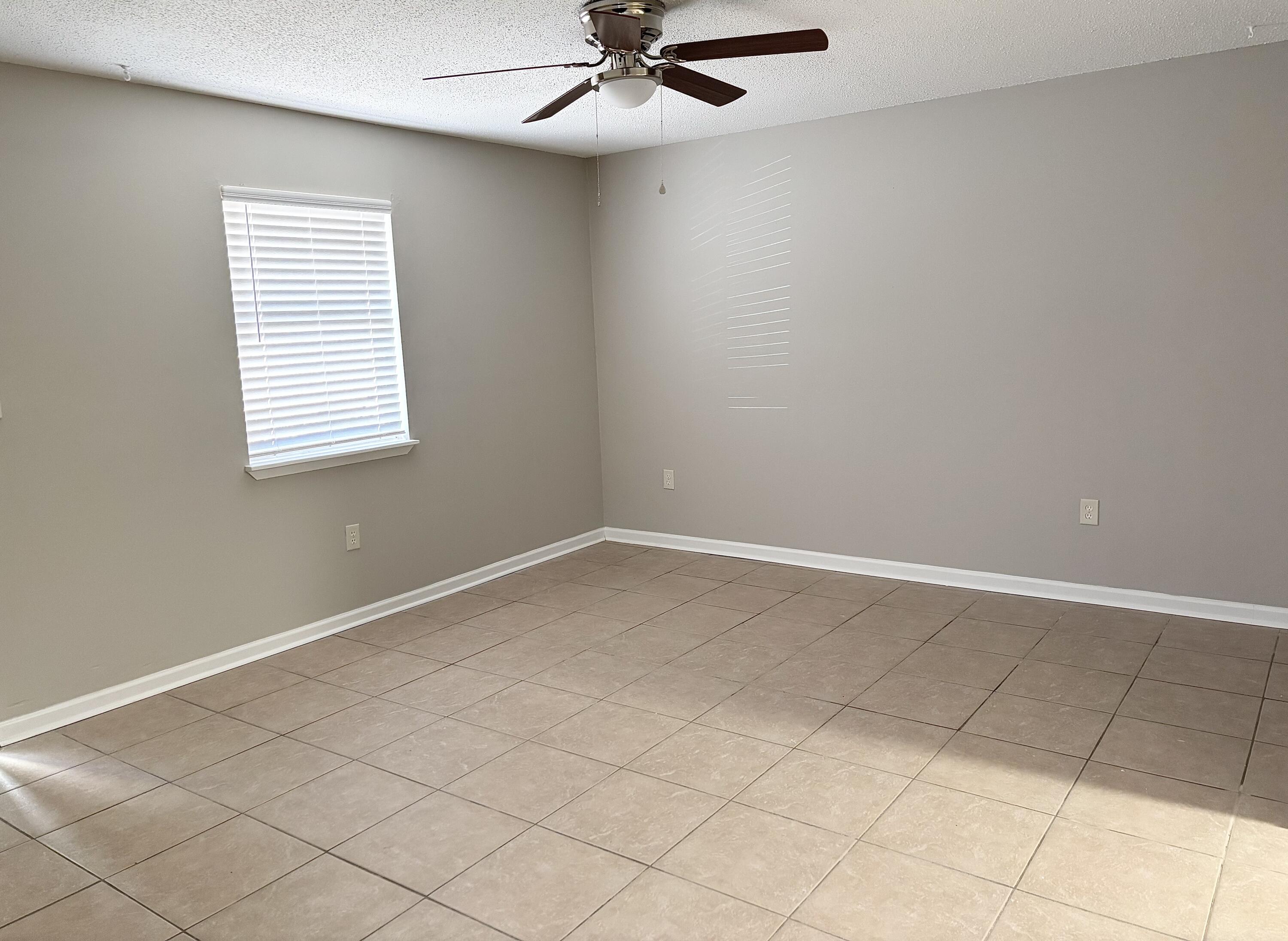 316 Lewis Street, Unit D Fort Walton Beach, FL 32547 - Photo 3 of 9 an empty room with windows and fan