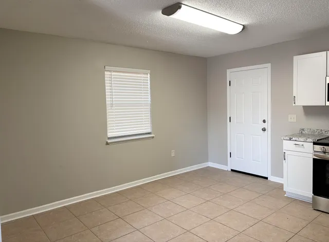 a kitchen with white cabinets and white appliances