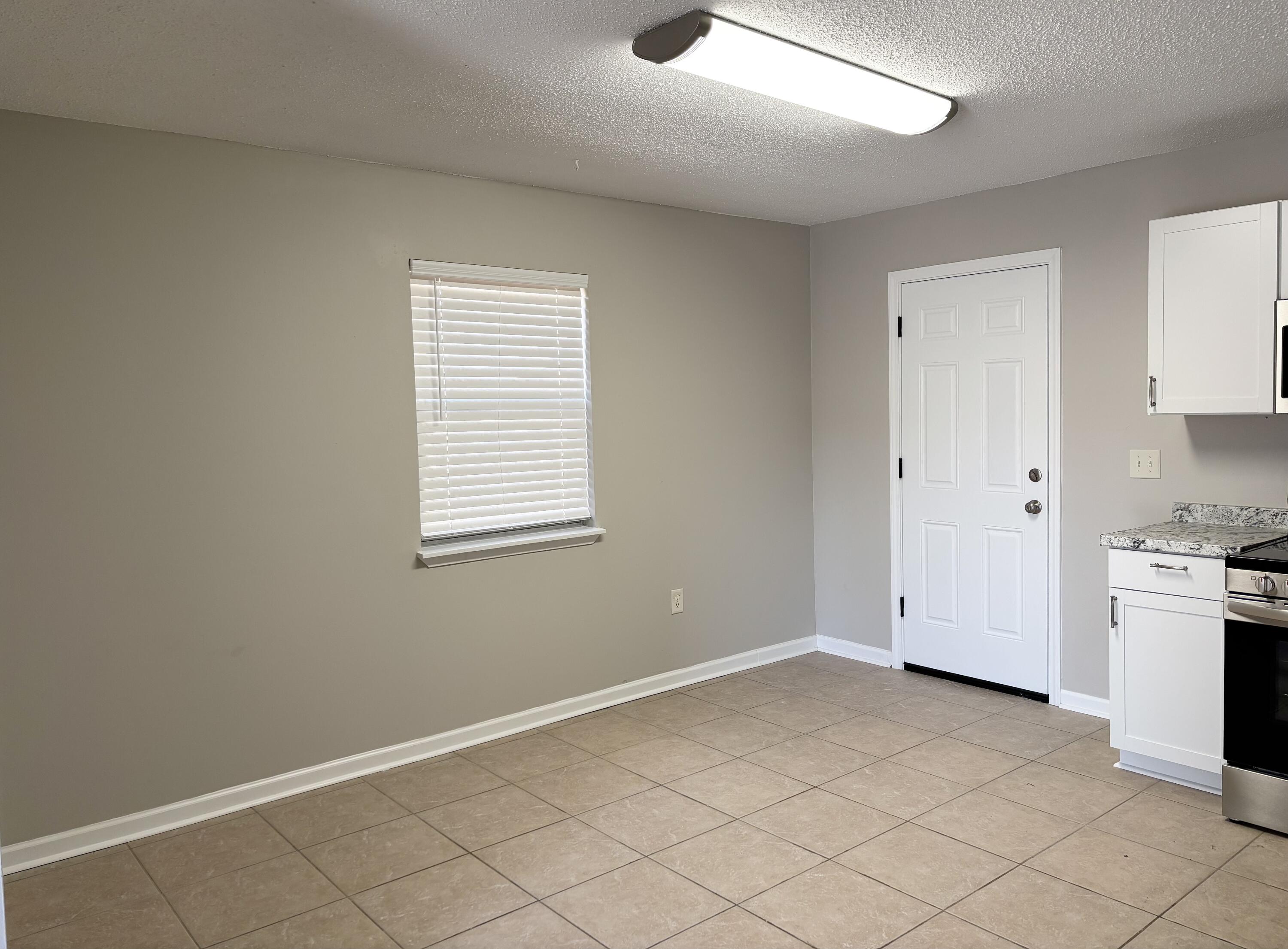 316 Lewis Street, Unit D Fort Walton Beach, FL 32547 - Photo 4 of 9 an empty room with windows