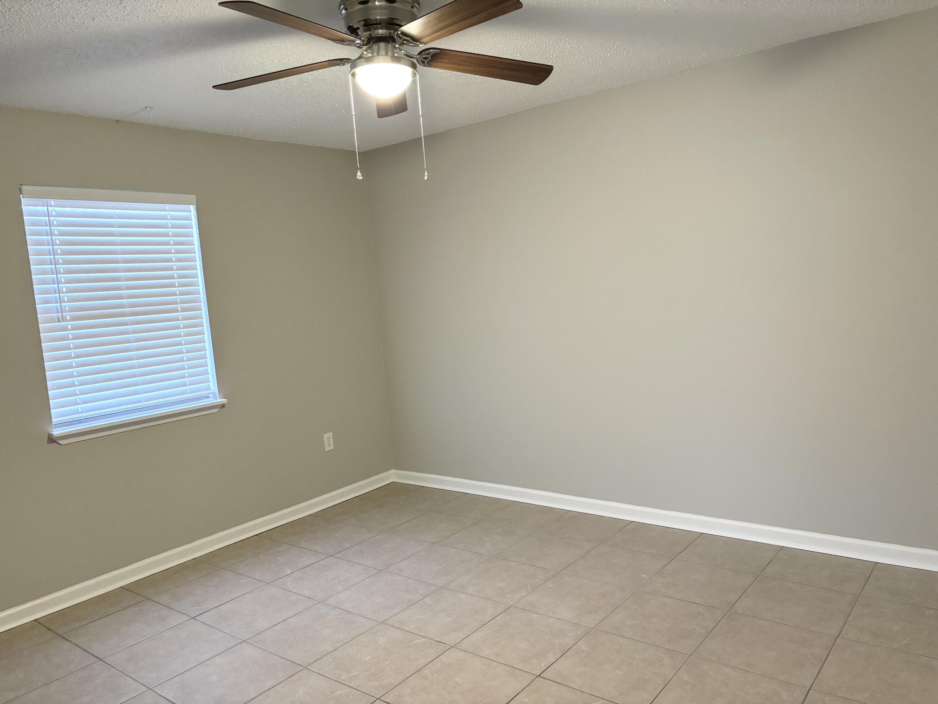 316 Lewis Street, Unit D Fort Walton Beach, FL 32547 - Photo 7 of 9 an empty room with a window and ceiling fan