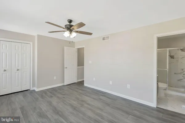 a view of a room with wooden floor and a ceiling fan