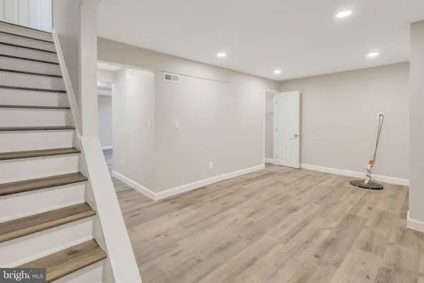 a view of an empty room with wooden floor and entryway
