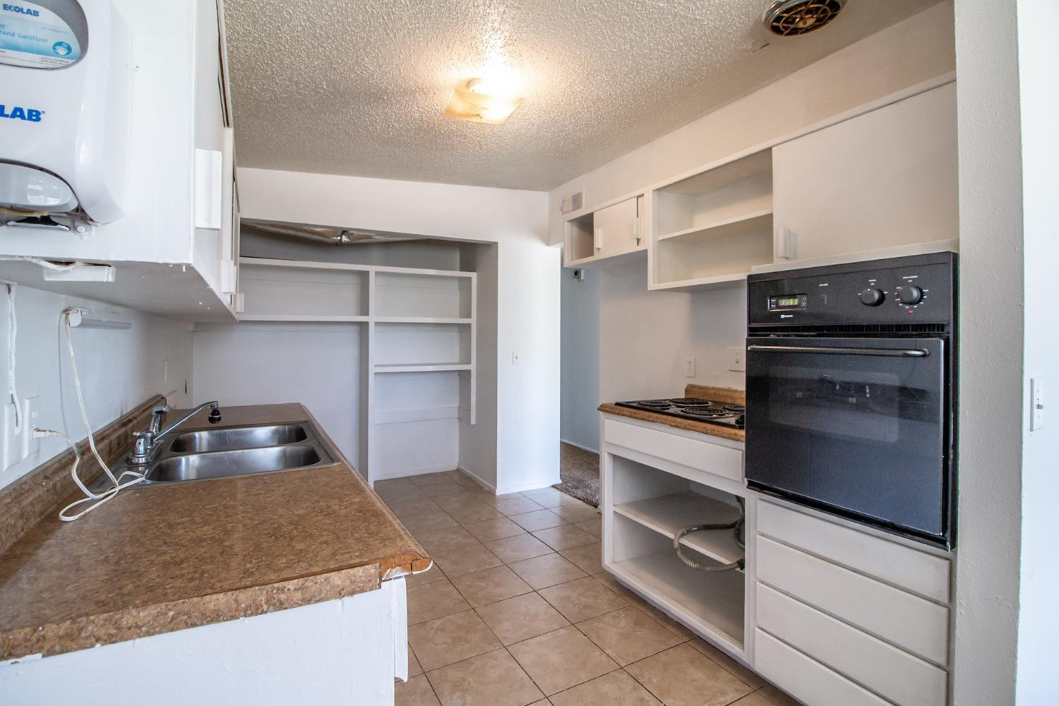 2714 62nd Street Lubbock, TX 79413 - Photo 12 of 28 a kitchen with a stove and a cabinets
