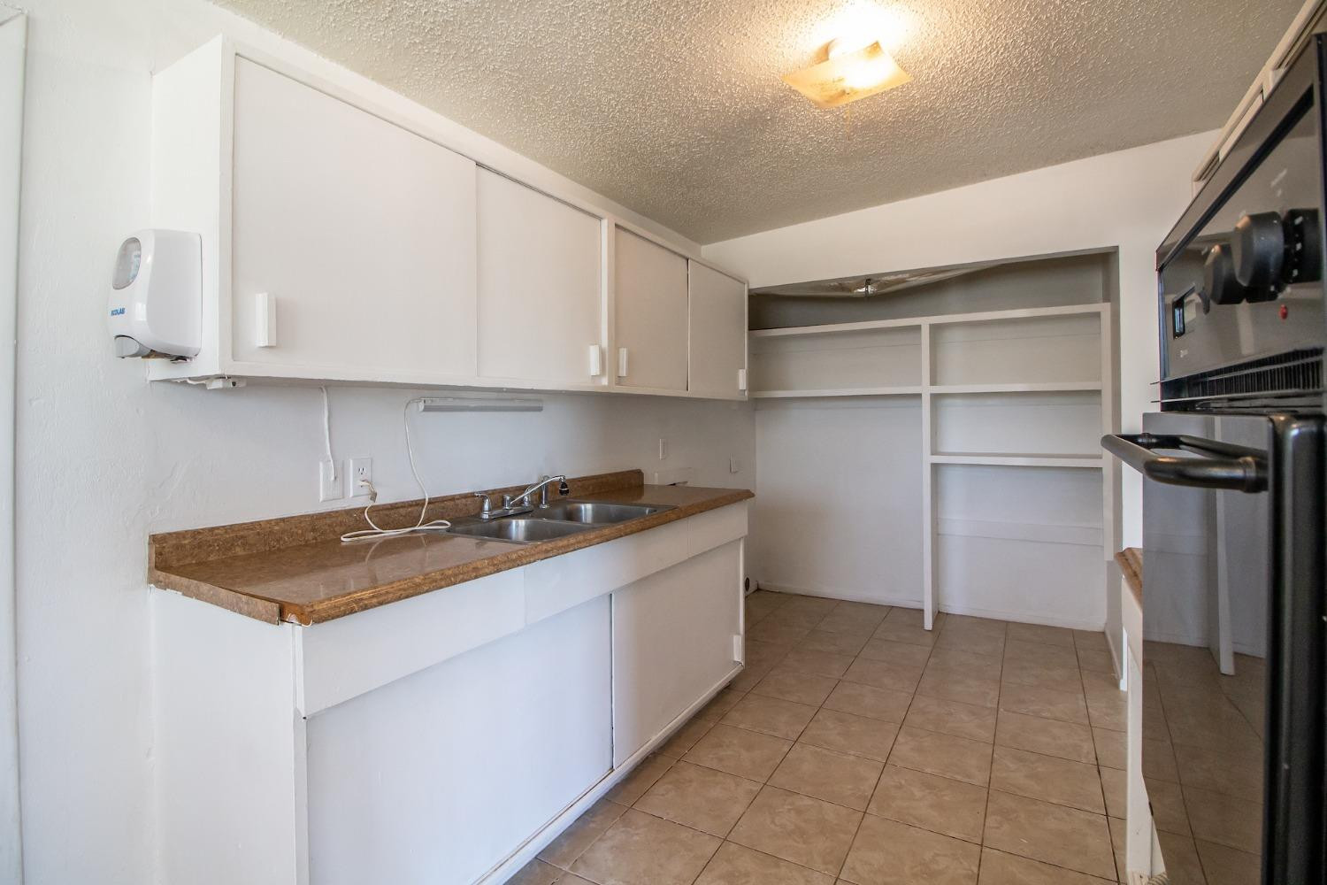 2714 62nd Street Lubbock, TX 79413 - Photo 13 of 28 a kitchen with a cabinets and a stove top oven