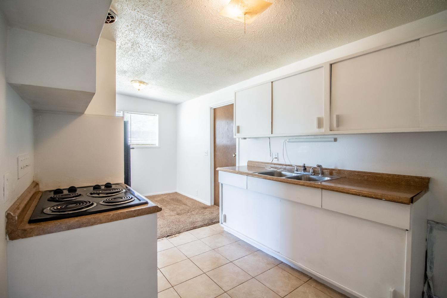2714 62nd Street Lubbock, TX 79413 - Photo 14 of 28 a kitchen with granite countertop a sink stove and cabinets