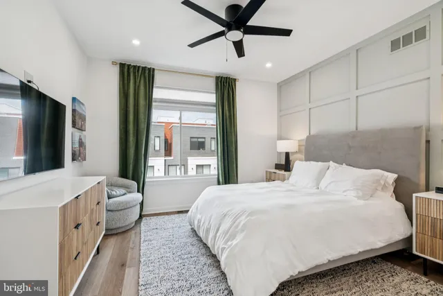 a bedroom with a bed and a large window