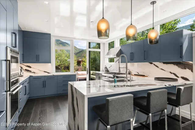 a kitchen with stainless steel appliances granite countertop a sink a stove and a refrigerator