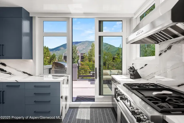 a kitchen with granite countertop a stove and a view of living room