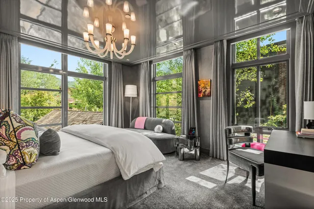 a bedroom with furniture and a large window