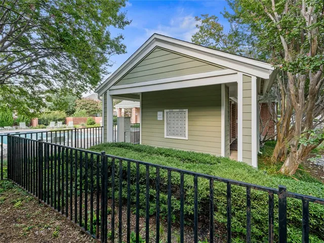 a view of a white house with a large trees