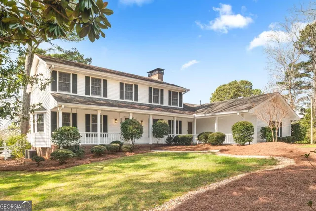 a front view of a house with swimming pool and porch