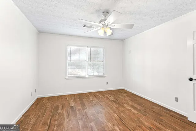 a view of an empty room with wooden floor