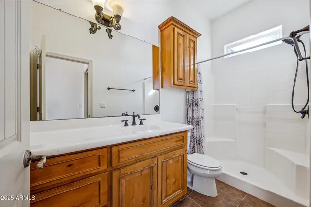 an empty room with chandelier fan and windows